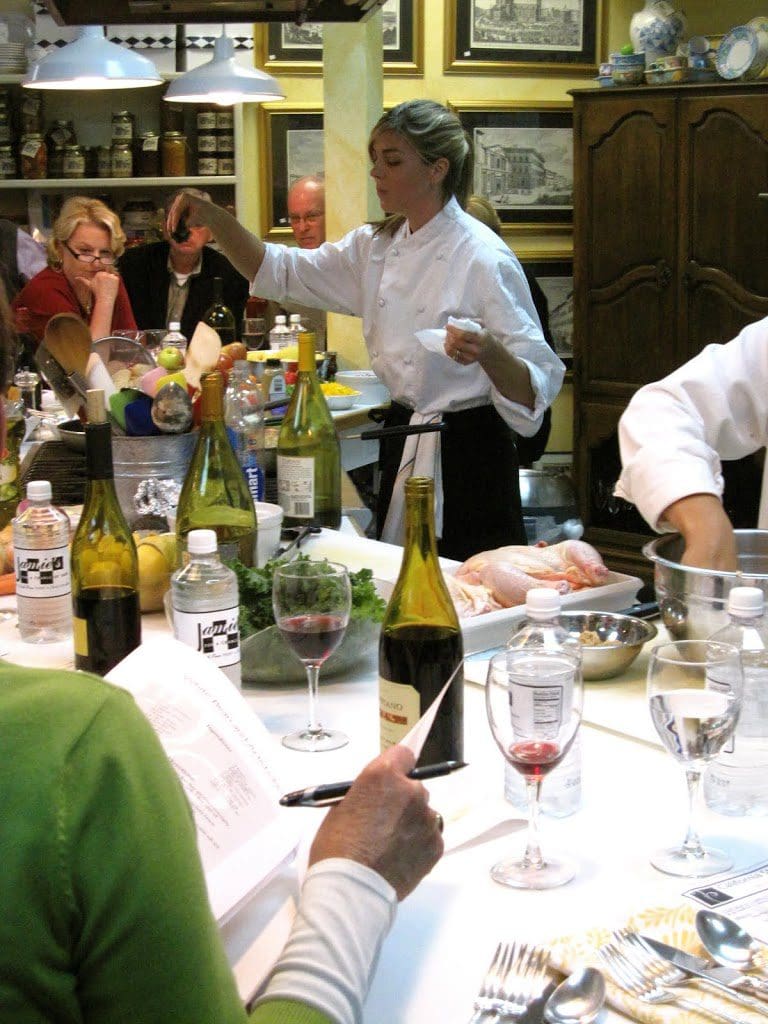 A group of people preparing food in a kitchen.