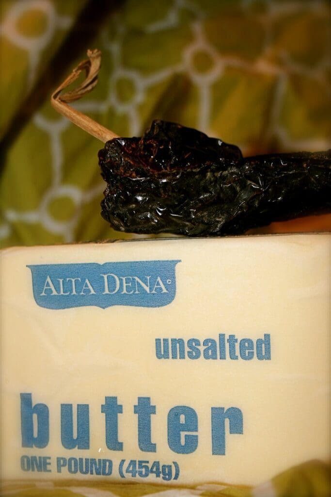 A block of unsweetened butter with a pepper on it.