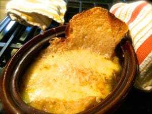 A bowl of French onion soup sits on the stove.