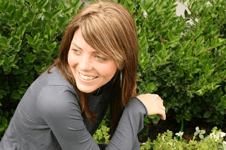 A woman sitting on a bench in a garden.