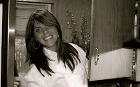 A woman standing in front of a refrigerator.
