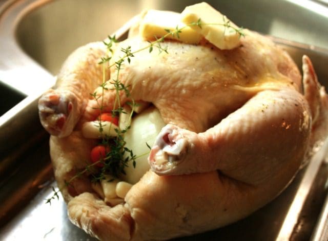 A roasted chicken is sitting in a pan.