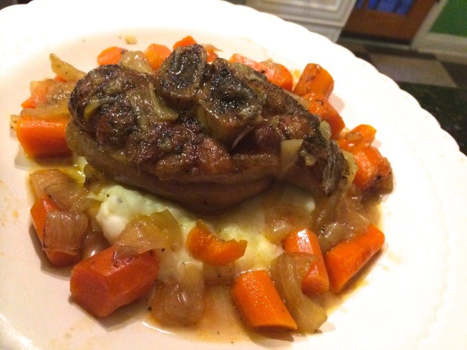 A plate with meat, carrots and mashed potatoes.