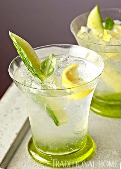 Two glasses with cucumber and mint garnished with ice.