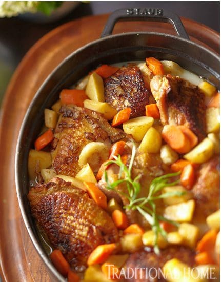 Chicken and potatoes in a cast iron pan.