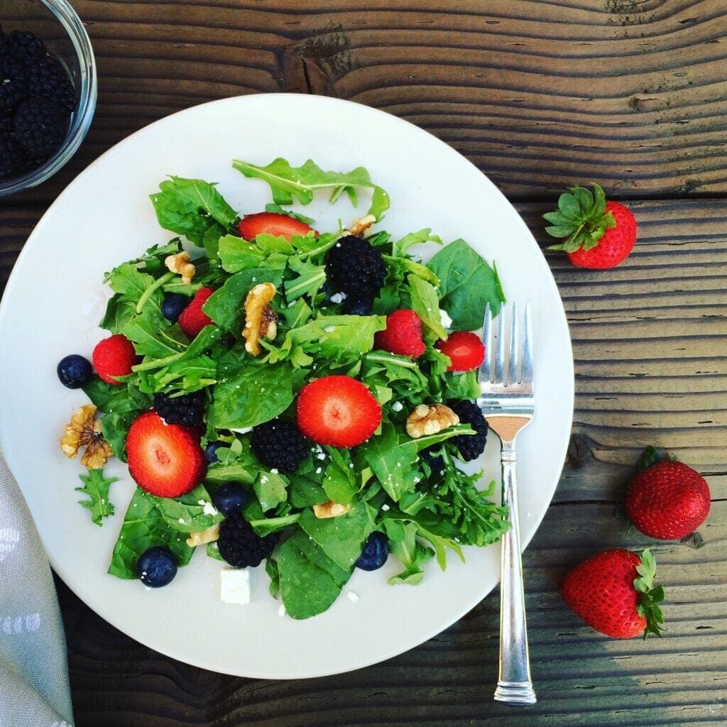 A plate with a berry salad on it, perfect for summer.