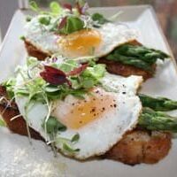 A fried egg and asparagus dish served on a plate.