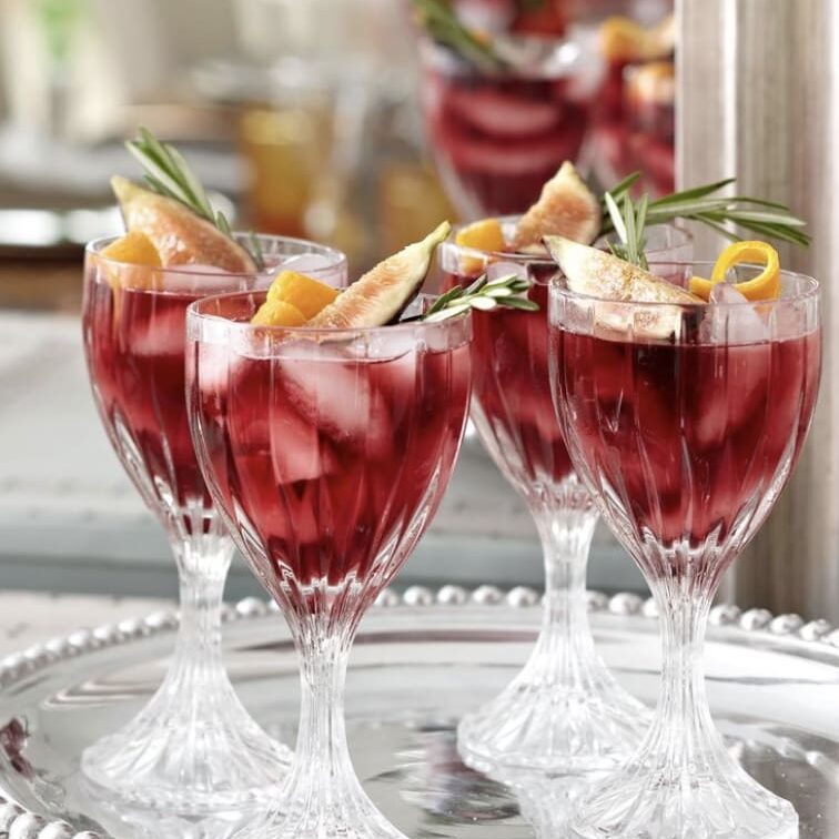 A glass of red sangria on a silver tray.