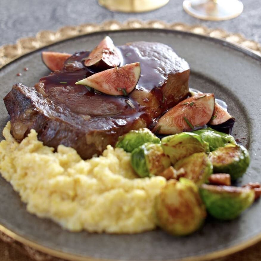 Steak with figs and brussels sprouts on a plate.