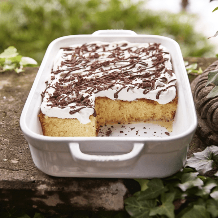 A white dish with a piece of cake on it.