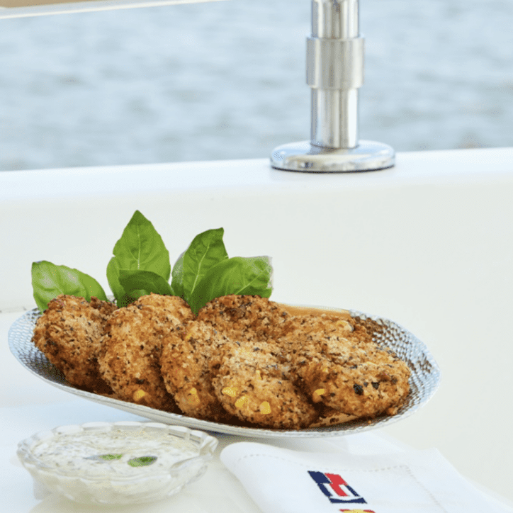 A plate of fish and chips on a table next to the water.