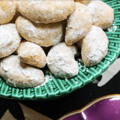 A bowl of cookies with powdered sugar in it.