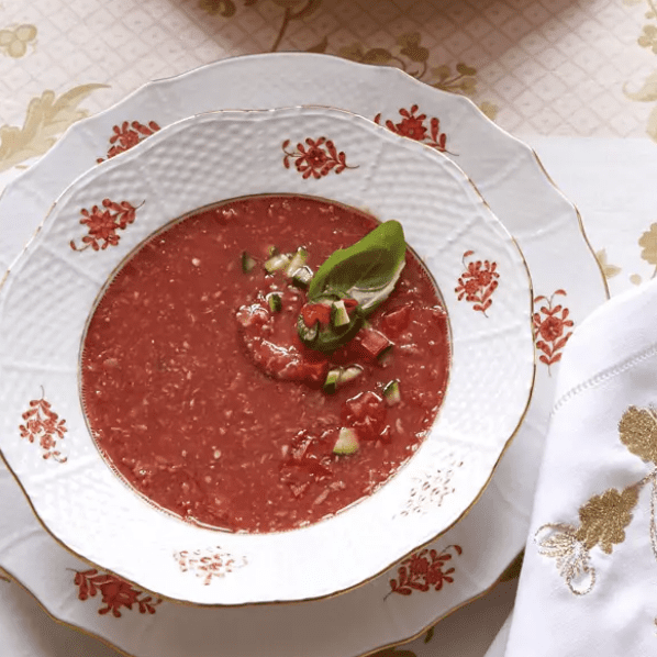 A bowl of tomato soup on a table.