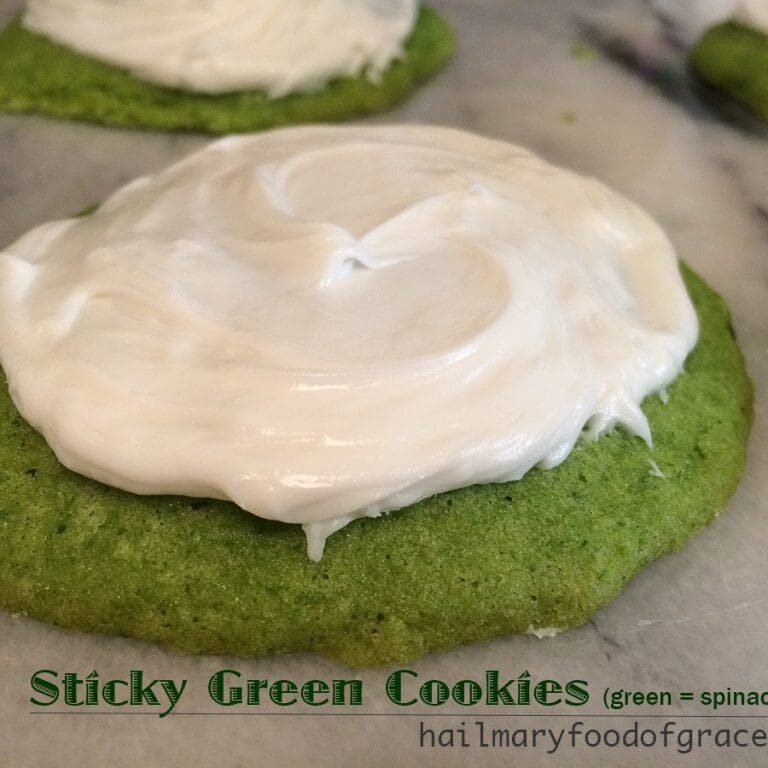 A green cookies with white frosting.