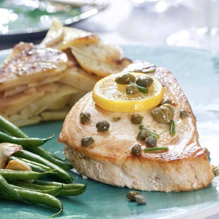 A plate with chicken and green beans on it.