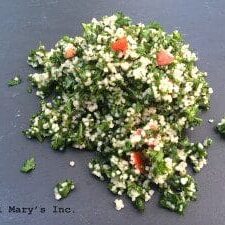 A pile of couscous on a black plate, perfect for a tabbouleh recipe.