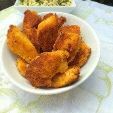 A bowl of fried chicken with a side of salad is displayed on the table.